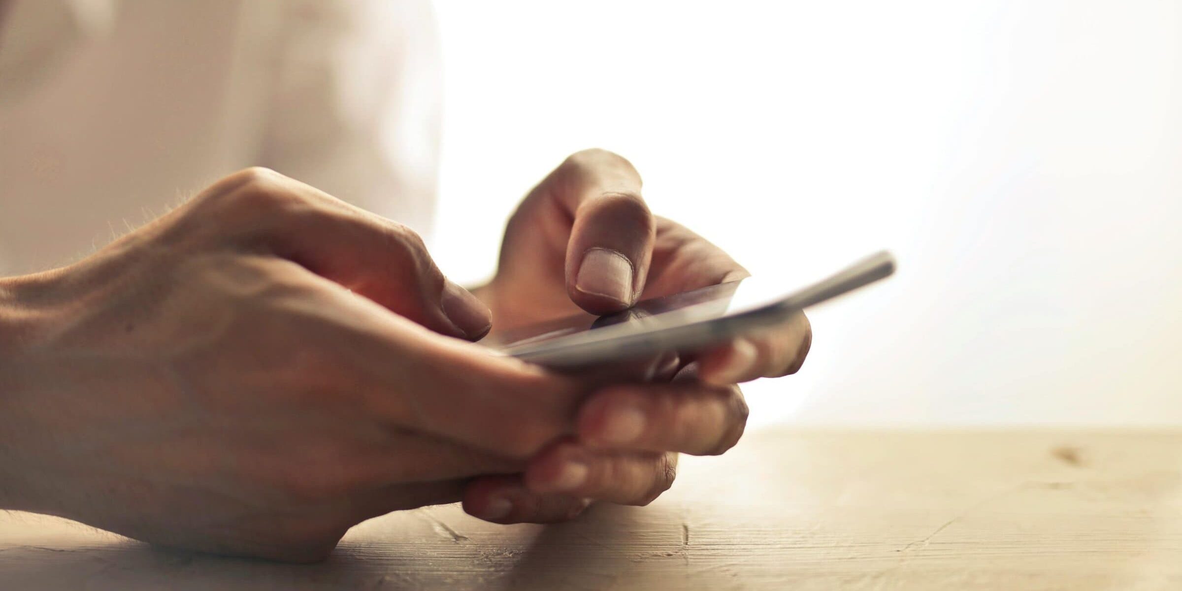 pexels-adrienn-638530-1458283 Two hands holding a smartphone.