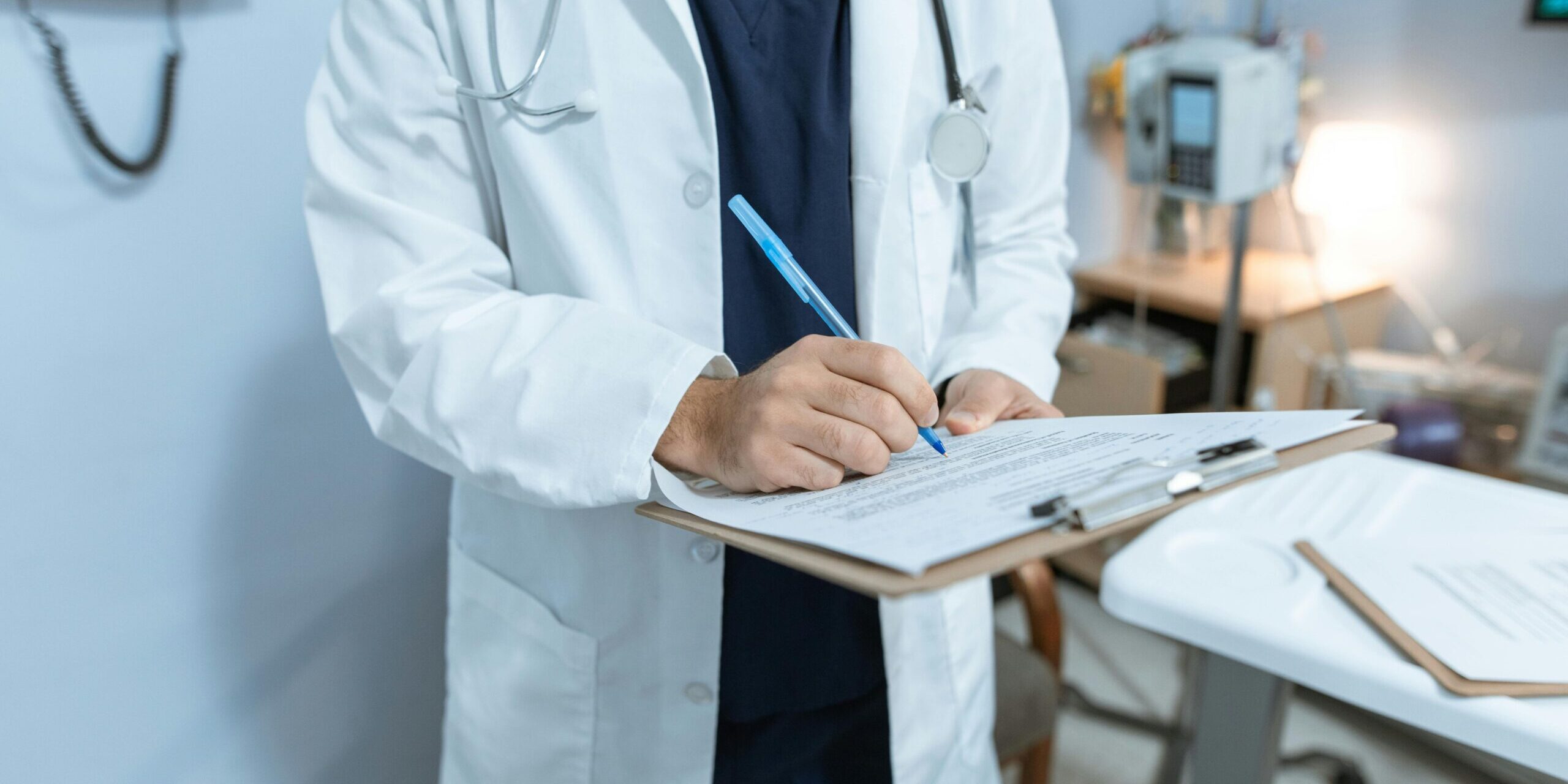 pexels-rdne-6129043 Hospital provider writing on clipboard.